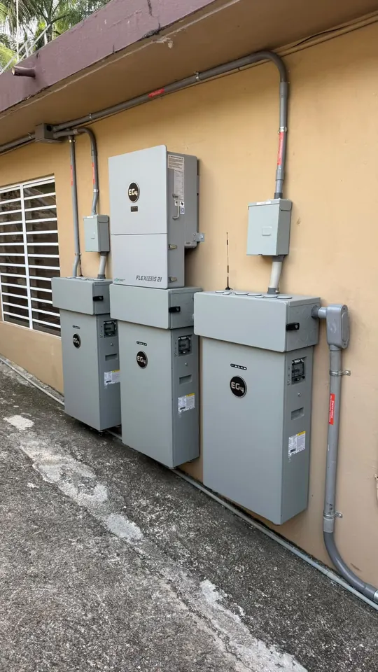 Inversor EG4 FlexBOSS21 con tres baterías EG4 instaladas en la pared exterior de una casa en Puerto Rico
